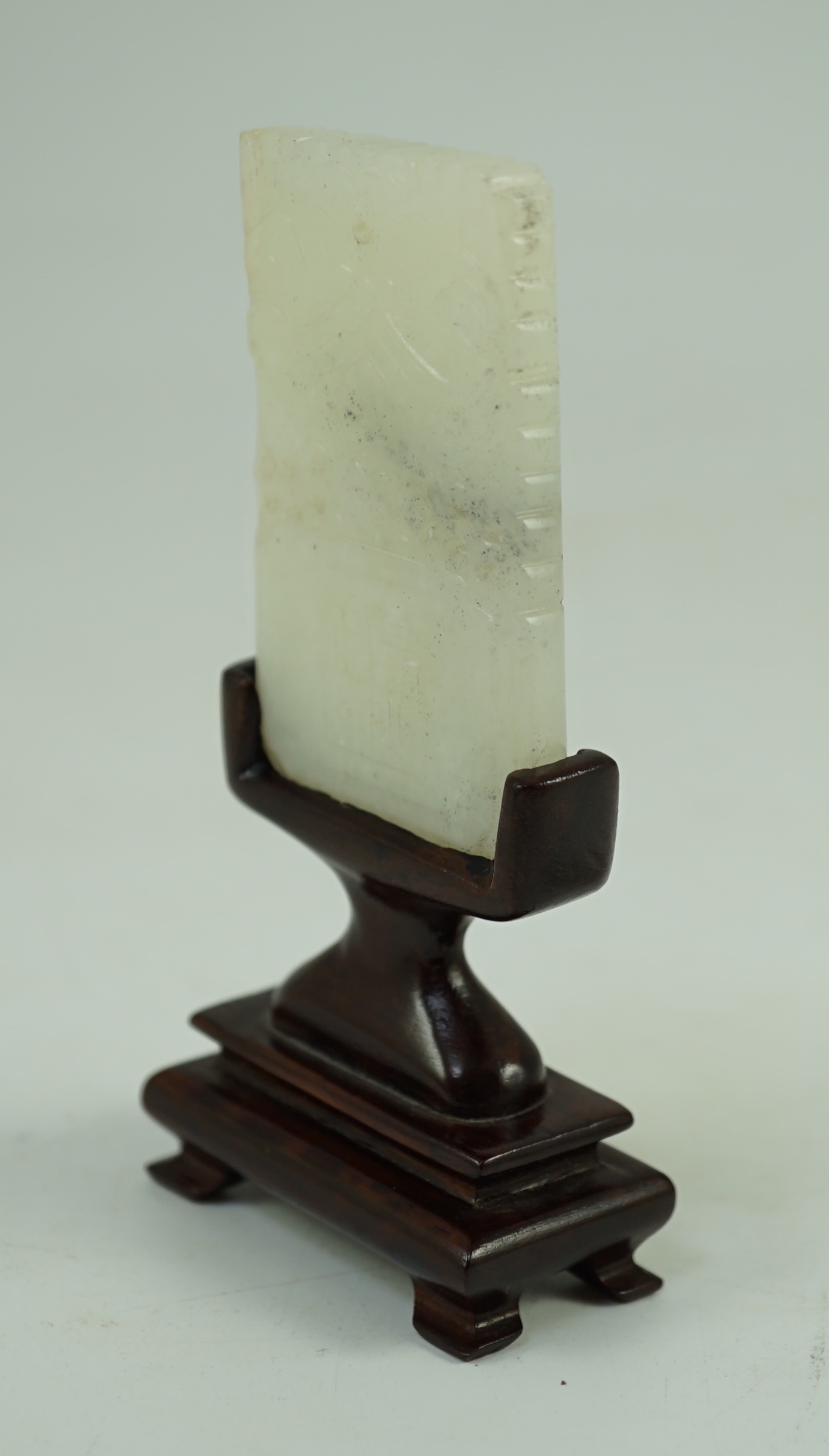 A Chinese inscribed white jade plaque, 19th century, 6.3 cm high, excluding wood stand